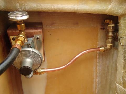 the gas regulator has a copper tube that runs to the gas valve. All this is in to the LP locker. Again, there is about 3/8" between the underside of the locker