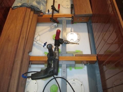 I tapped everthing off to prevent sawdust from falling down into the bilge. I used the right angle adapter and a standard and long bit to drill the holes.