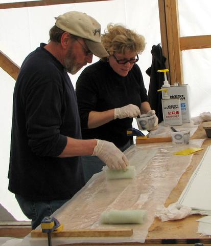 Bruce rolling up wetted out tape to be passed up to John on the scaffolding.