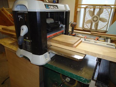 By adding a dead flat board under the teak I was able to use my thickness planer as a jointer. Note the small cleat hot glued to the plank to keep the teak from