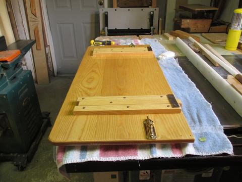 After the eight coats of varnish it was time to reinstalled the parts on the underside of the table.