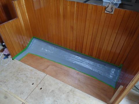 Two coats of grey Bilge-Kote paint to cover the fiberglass in the locker bottom.