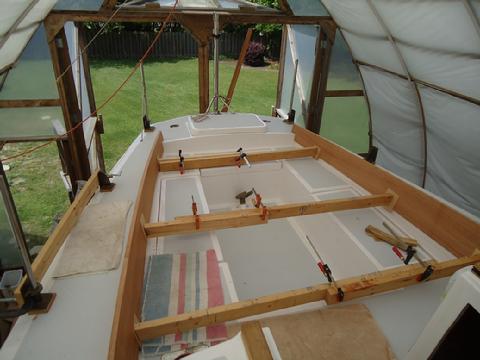 I cut ten degree angles on the 2x4 braces and leveraged them into position to bend the 7/8" thick mahogany flush to the edge of the molded cockpit.