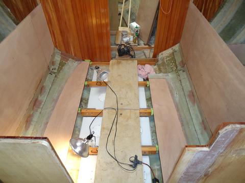 The settee backs have been glassed in place. I faired the holes I cut in the biaxial to allow water to drain out. The old locker bottoms are sanded clean.