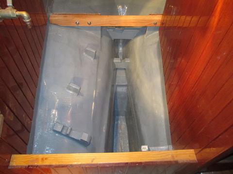 Looking aft under the old engine compartment. I glassed in brackets to hold a couple of the back up anchor in place in the bilge and then painted the remaining