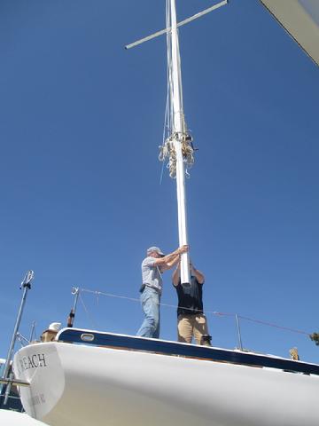 Rick and I contolling the lower end of the mast while Sergio slowly moved the mast forward. I ran some red 1/4" line through the stanchions to serve as temporar