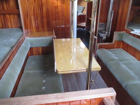 This is the normal position of the table with the fiddle on the port side. You would sit on this side when on the starboard tack. The fiddle secures objects on